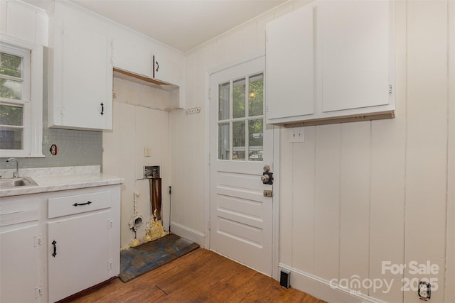 clothes washing area with dark wood-style floors, crown molding, and a sink