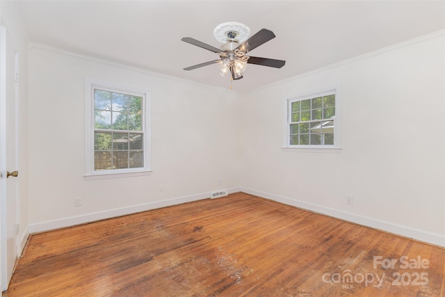 spare room featuring ornamental molding, baseboards, wood finished floors, and ceiling fan