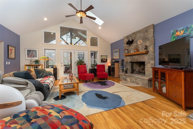 27 Hunting Lodge Dr, Black Mountain, NC 28711 - living room featuring ceiling fan, light wood finished floors, a fireplace, high vaulted ceiling, and a skylight