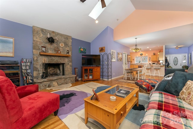 27 Hunting Lodge Dr, Black Mountain, NC 28711 - living area with a stone fireplace, wood finished floors, a skylight, and high vaulted ceiling