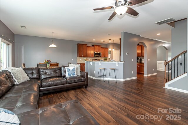 4924 Riverdale Dr, Charlotte, NC 28273 - living area featuring visible vents, arched walkways, ceiling fan, and dark wood-style flooring