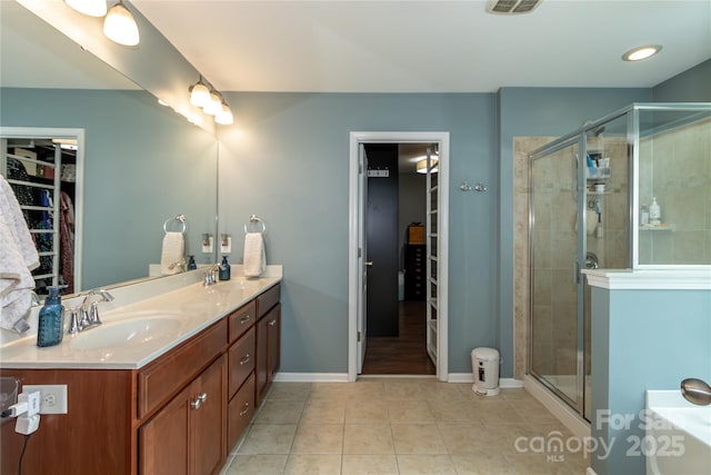 4924 Riverdale Dr, Charlotte, NC 28273 - full bathroom with a spacious closet, tile patterned floors, a sink, and a stall shower