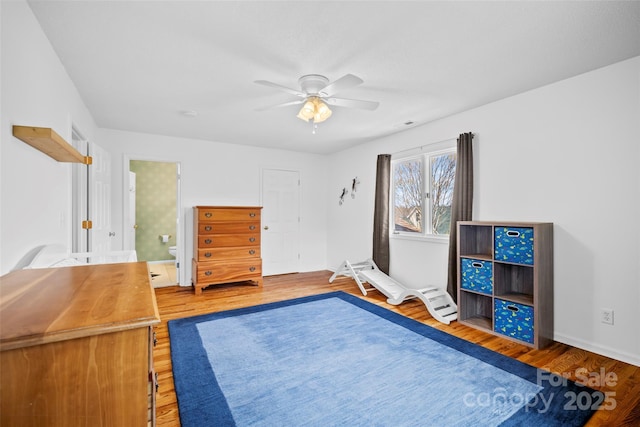 unfurnished bedroom featuring ensuite bath, a ceiling fan, and light wood-type flooring