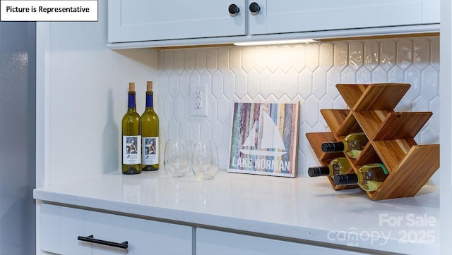 152 Ventor Way, Mooresville, NC 28115 - room details featuring backsplash, light stone counters, and white cabinets