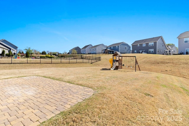 view of yard with a playground, a residential view, fence, and a patio