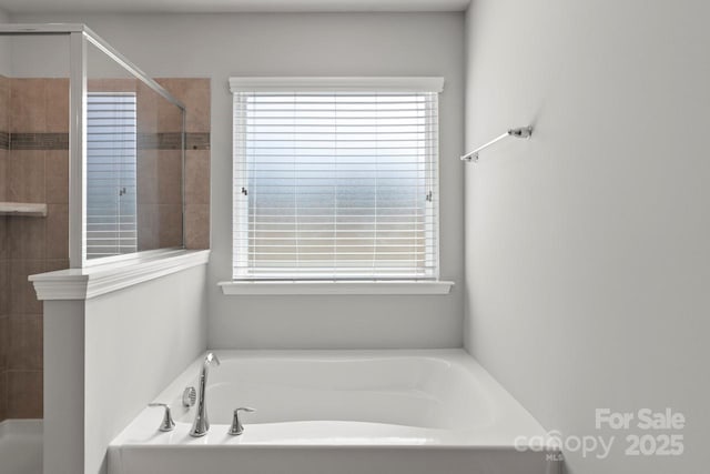full bath featuring a stall shower and a garden tub