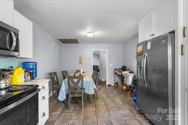 3612 Winterfield Pl, Charlotte, NC 28205 - kitchen featuring tasteful backsplash, light countertops, white cabinets, and stainless steel appliances