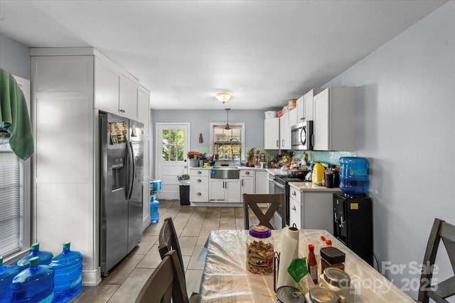 3612 Winterfield Pl, Charlotte, NC 28205 - kitchen featuring tasteful backsplash, white cabinets, a sink, light countertops, and stainless steel appliances