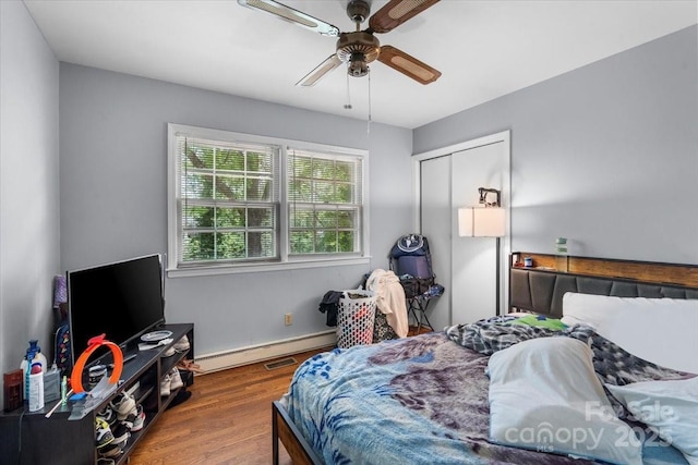 3612 Winterfield Pl, Charlotte, NC 28205 - bedroom featuring a closet, a baseboard radiator, a ceiling fan, and wood finished floors