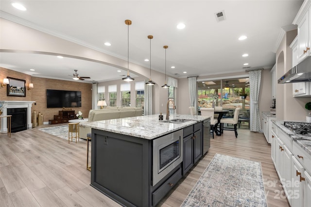 kitchen featuring a sink, white cabinets, ceiling fan, and stainless steel appliances