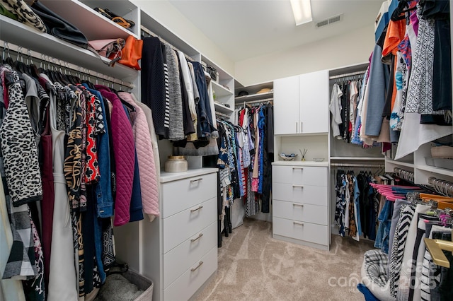 walk in closet featuring visible vents and light colored carpet