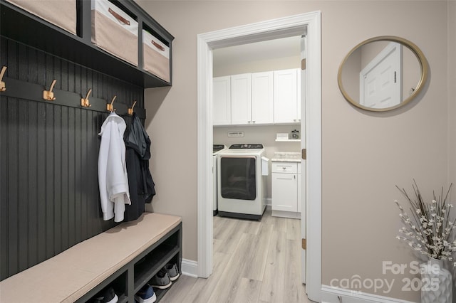 mudroom featuring light wood-style flooring and washing machine and clothes dryer