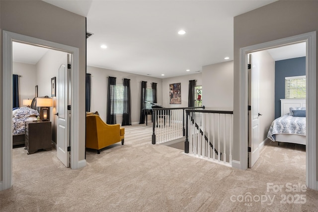 hallway featuring carpet flooring, baseboards, an upstairs landing, and recessed lighting