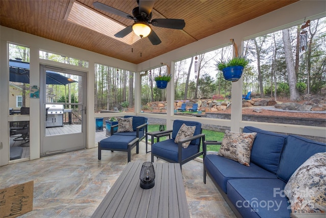 sunroom featuring a ceiling fan and an outdoor hangout area