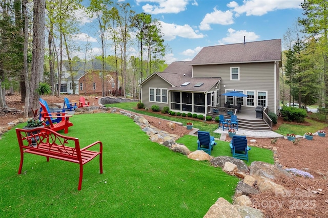 rear view of property with a shingled roof, a wooden deck, a sunroom, and a lawn
