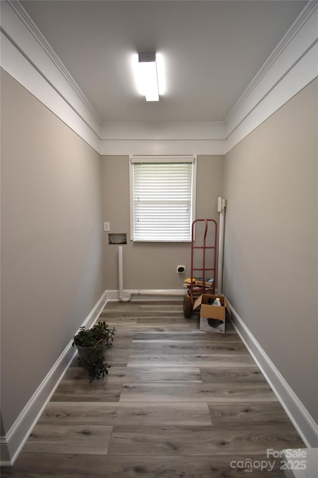unfurnished room featuring ornamental molding, baseboards, and wood finished floors