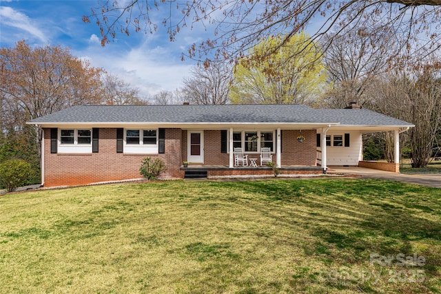 single story home with a front lawn, an attached carport, brick siding, and driveway