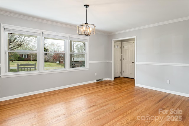 unfurnished room with light wood finished floors, baseboards, visible vents, ornamental molding, and an inviting chandelier