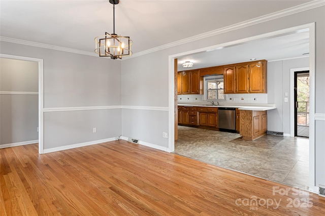 kitchen with light countertops, dishwasher, brown cabinets, light wood-type flooring, and an inviting chandelier