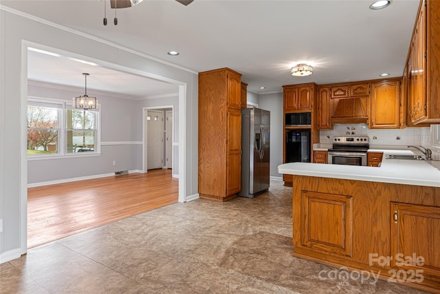 kitchen featuring crown molding, brown cabinets, stainless steel appliances, premium range hood, and a sink