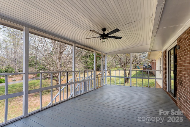 wooden terrace with a lawn and a ceiling fan