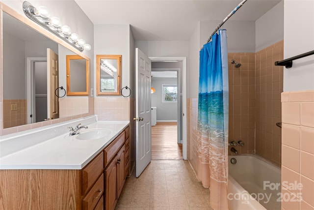 full bathroom featuring tile walls, shower / tub combo with curtain, tile patterned flooring, and vanity