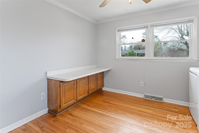 unfurnished office with a ceiling fan, light wood-style flooring, baseboards, visible vents, and ornamental molding