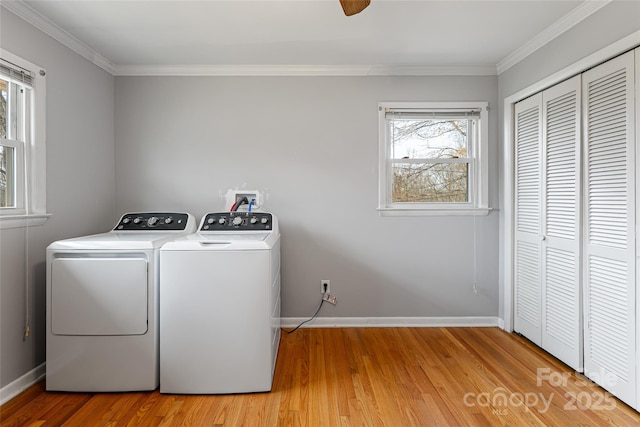 laundry room with washing machine and clothes dryer, crown molding, light wood finished floors, and laundry area