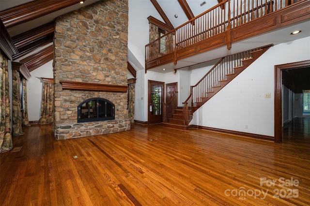 418 3rd St NE, Hickory, NC 28601 - unfurnished living room featuring high vaulted ceiling, baseboards, hardwood / wood-style floors, and a fireplace