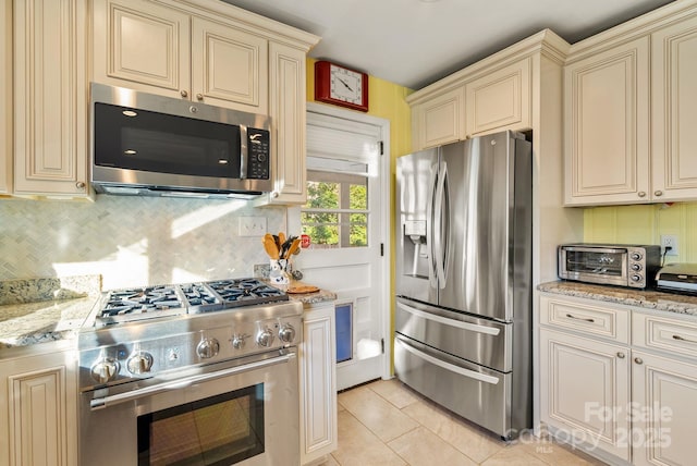 2 Bevlyn Dr, Asheville, NC 28803 - kitchen with a toaster, backsplash, appliances with stainless steel finishes, and cream cabinets