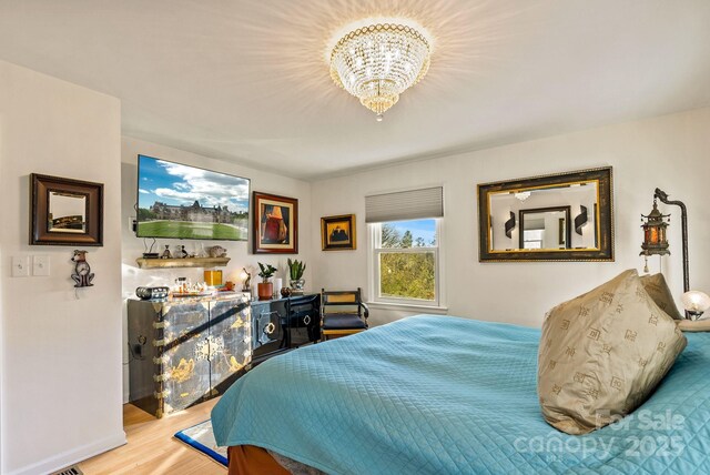 2 Bevlyn Dr, Asheville, NC 28803 - bedroom featuring wood finished floors and an inviting chandelier