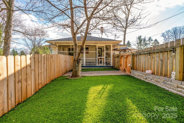 2 Bevlyn Dr, Asheville, NC 28803 - back of property with a fenced backyard, a sunroom, a yard, and stucco siding