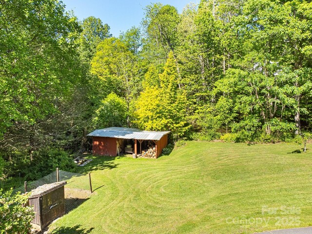 570 Brandon Rd, Black Mountain, NC 28711 - view of green lawn featuring a pole building, an outdoor structure, and a view of trees