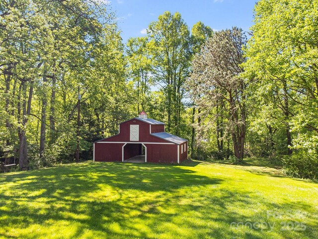 570 Brandon Rd, Black Mountain, NC 28711 - view of green lawn with a barn, an outbuilding, a garage, and a view of trees
