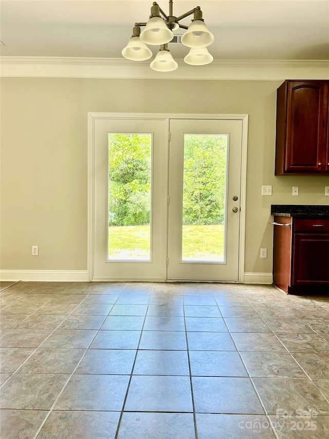entryway with baseboards, a notable chandelier, crown molding, and light tile patterned flooring