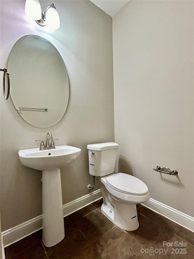 bathroom with tile patterned floors, toilet, and baseboards