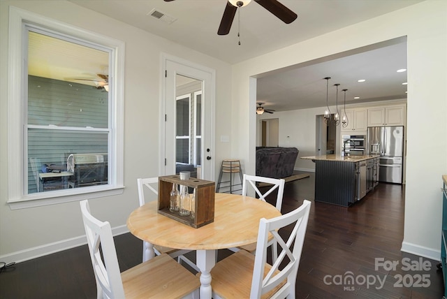 dining space with dark wood-style flooring, visible vents, and a ceiling fan