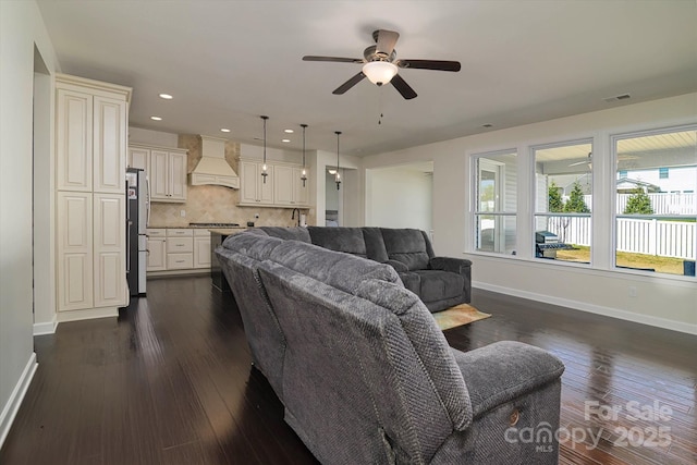 living area featuring visible vents, baseboards, ceiling fan, recessed lighting, and dark wood finished floors