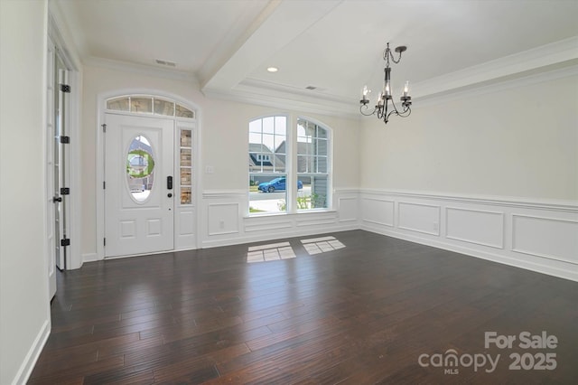 foyer entrance with an inviting chandelier, ornamental molding, dark wood-style floors, and visible vents