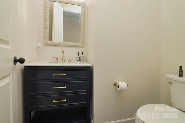 half bath with baseboards, toilet, and vanity