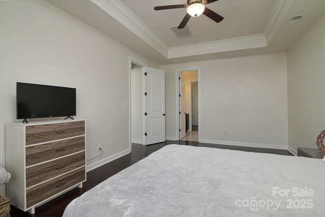 bedroom with a tray ceiling, baseboards, visible vents, and dark wood finished floors