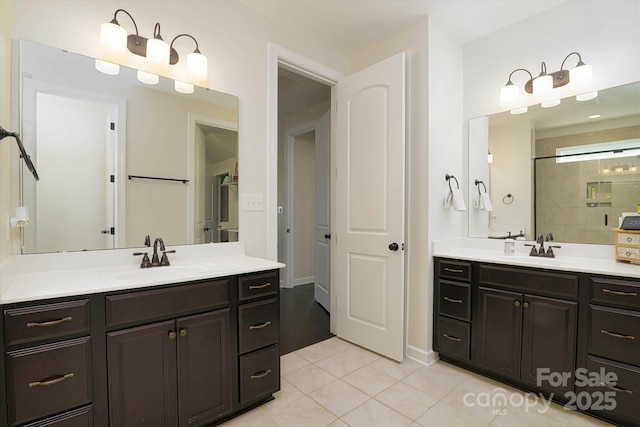 bathroom featuring a tile shower, a sink, tile patterned floors, and two vanities