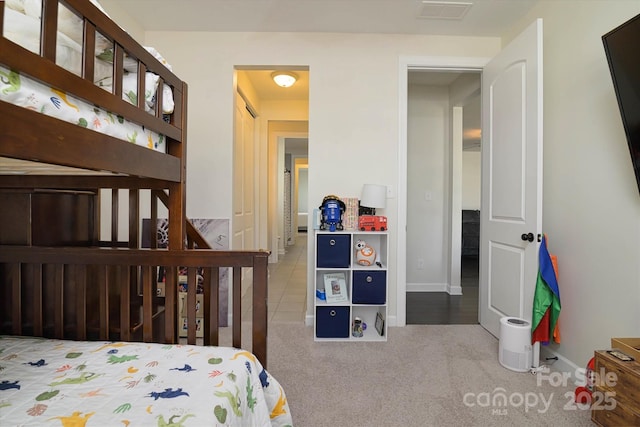 carpeted bedroom featuring baseboards and visible vents