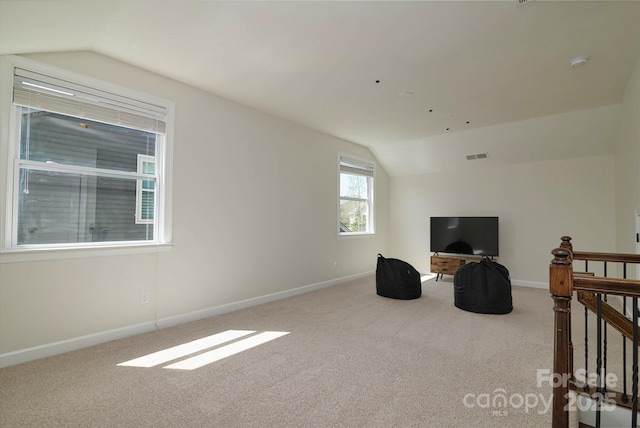 interior space with lofted ceiling, visible vents, and carpet