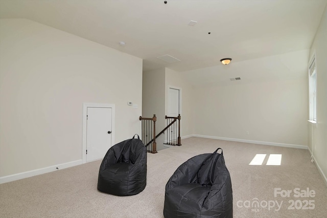 sitting room with baseboards, an upstairs landing, and carpet