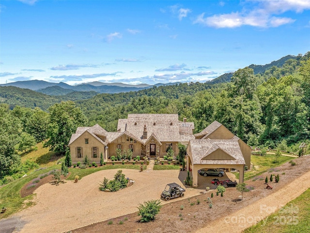 birds eye view of property featuring a view of trees and a mountain view