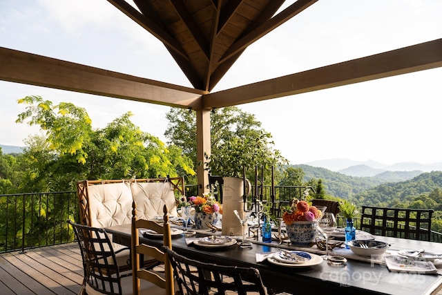 deck with a mountain view and outdoor dining space