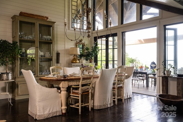 dining space with wood walls, vaulted ceiling, and hardwood / wood-style floors