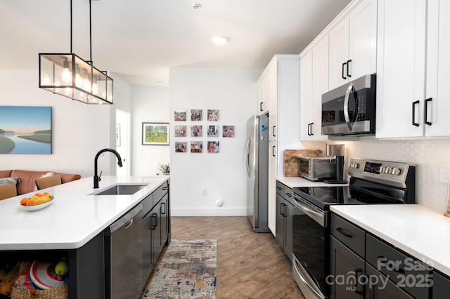 55 S Market St Unit 101, Asheville, NC 28801 - kitchen with a sink, light countertops, appliances with stainless steel finishes, and an island with sink