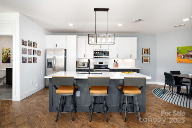 55 S Market St Unit 101, Asheville, NC 28801 - kitchen featuring visible vents, baseboards, appliances with stainless steel finishes, and a kitchen island with sink